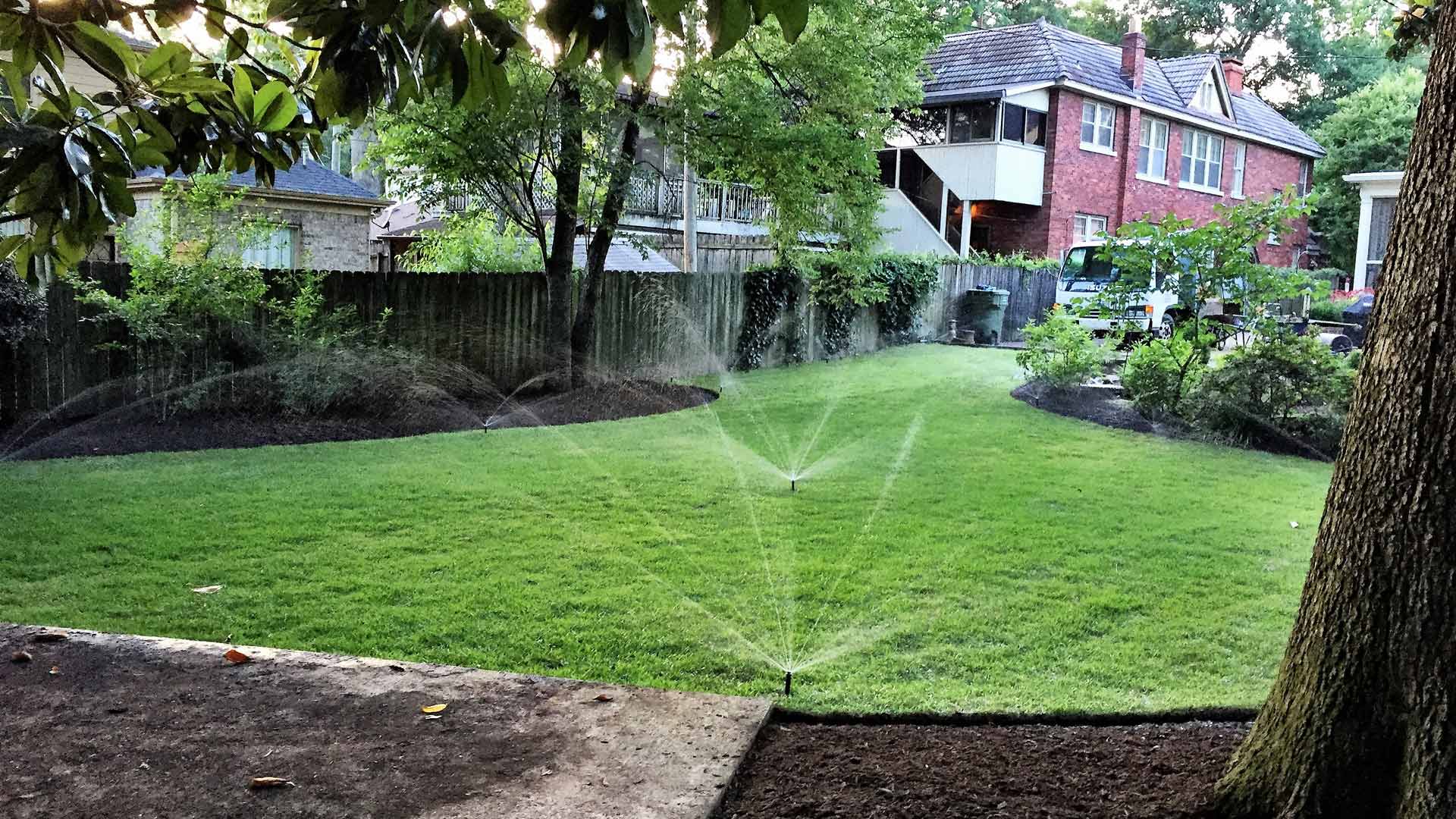 Irrigation sprinklers watering a backyard in Cooper-Young, TN.