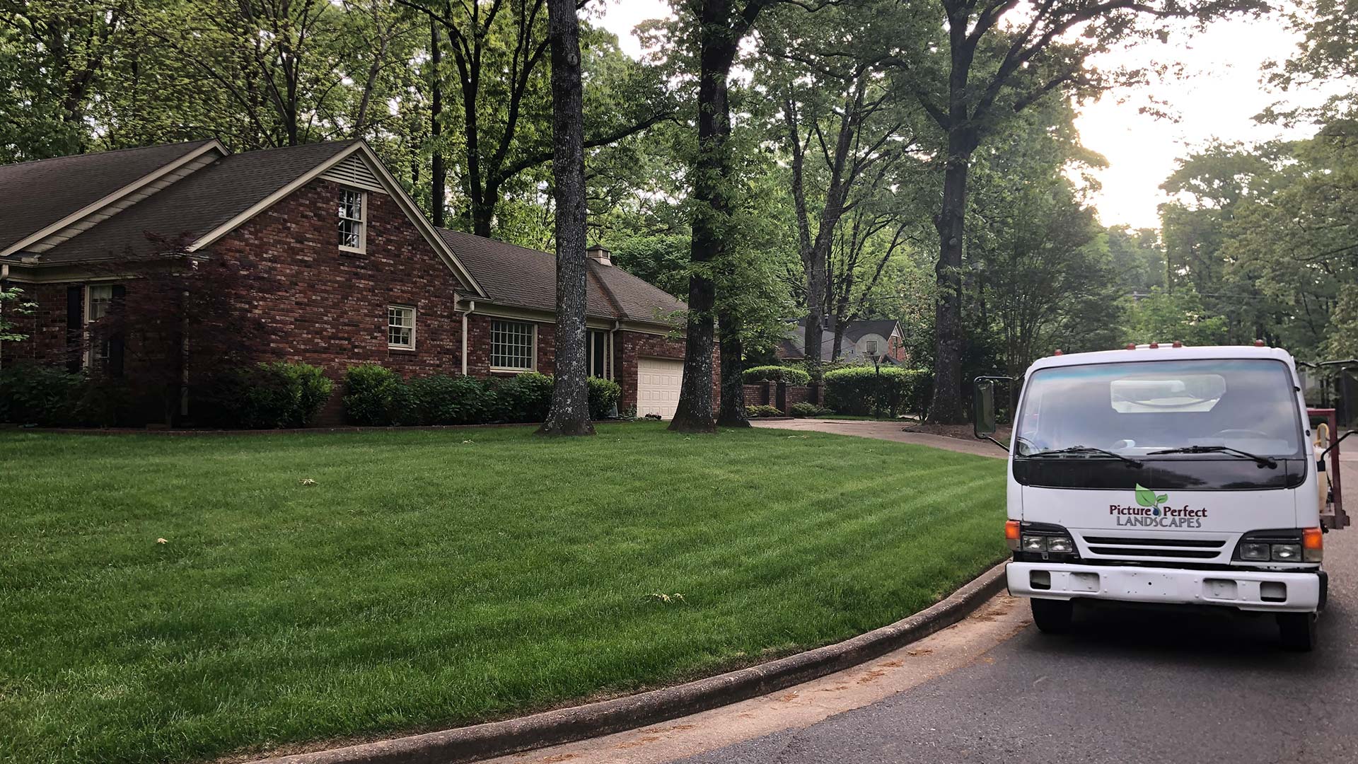 Picture Perfect Landscapes work truck by a beautiful lawn in Arlington, TN.