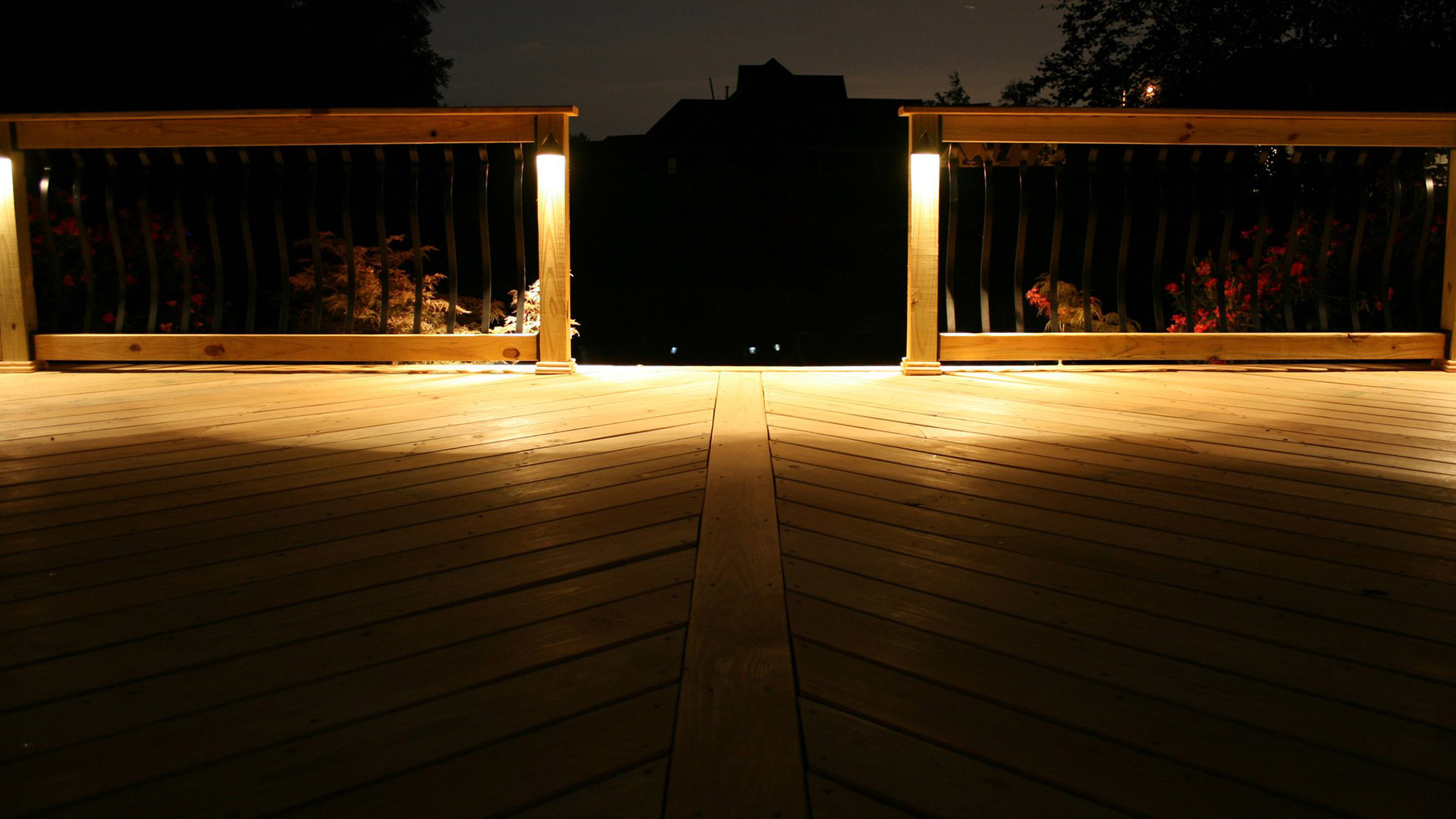 A wooden deck patio lit up at night by a home in Lakeland, TN.