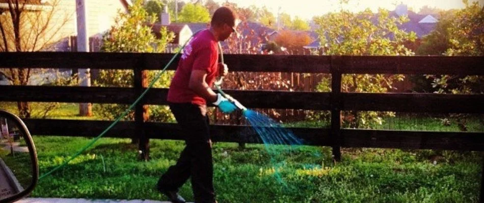 Lawn service employee in Memphis, TN, fertilizing lawn.