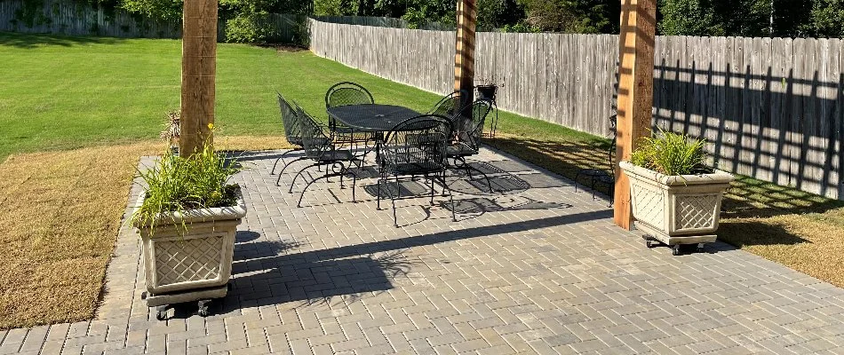 Paver patio in Memphis, TN, with a black table set and planters.