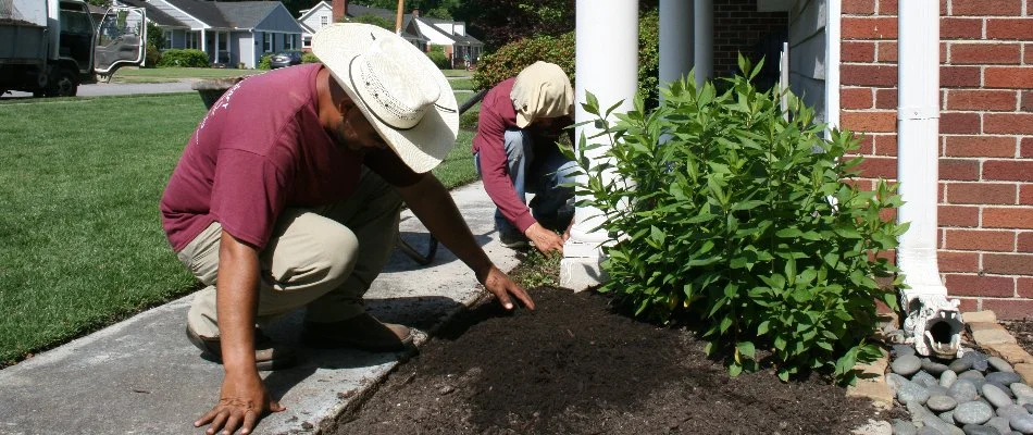 Workers spreading mulch in a landscape bed in Memphis, TN.