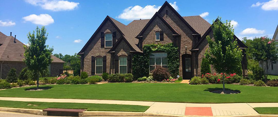 A brown home with a large healthy front lawn in East Memphis, TN.