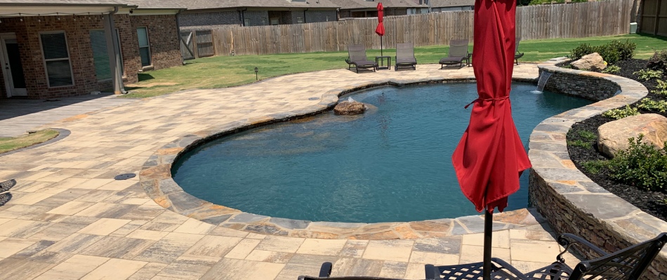Custom patio built by pool in backyard in High Point Terrace, TN.