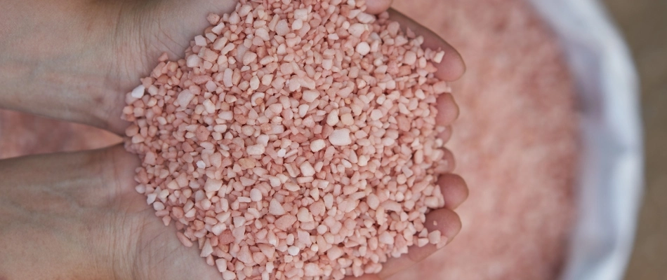 Handful of potassium pellets for fertilizer treatment in professional's hands in Bartlett, TN.