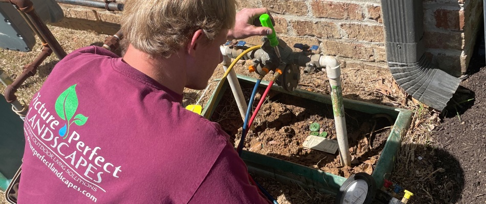 Professional performing a startup service for irrigation system in East Memphis, TN.